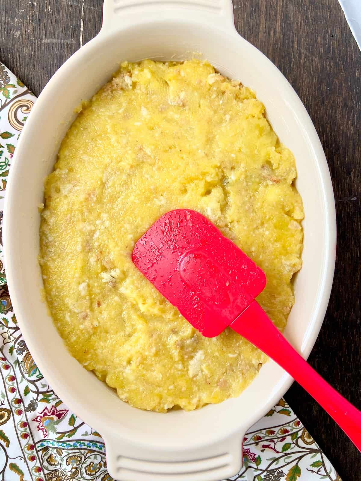 Cooked acorn squash in buttered casserole dish.