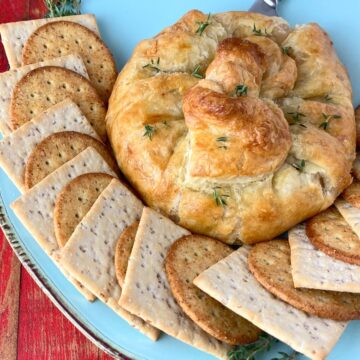 Baked brie on plate with crackers.
