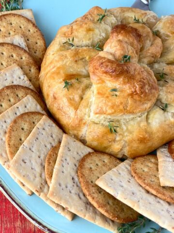 Baked brie on plate with crackers.