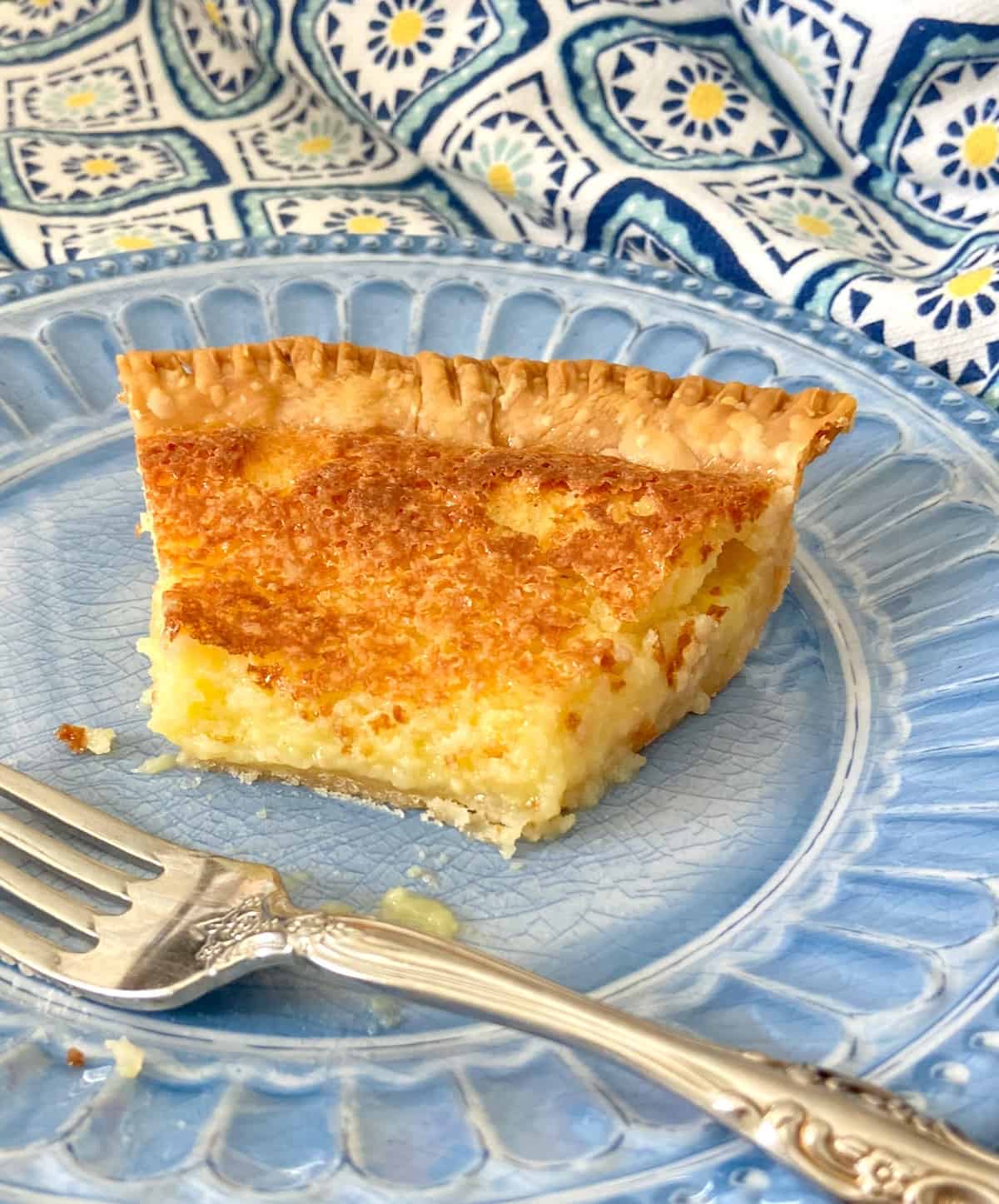 Buttermilk pie on blue plate with a fork.