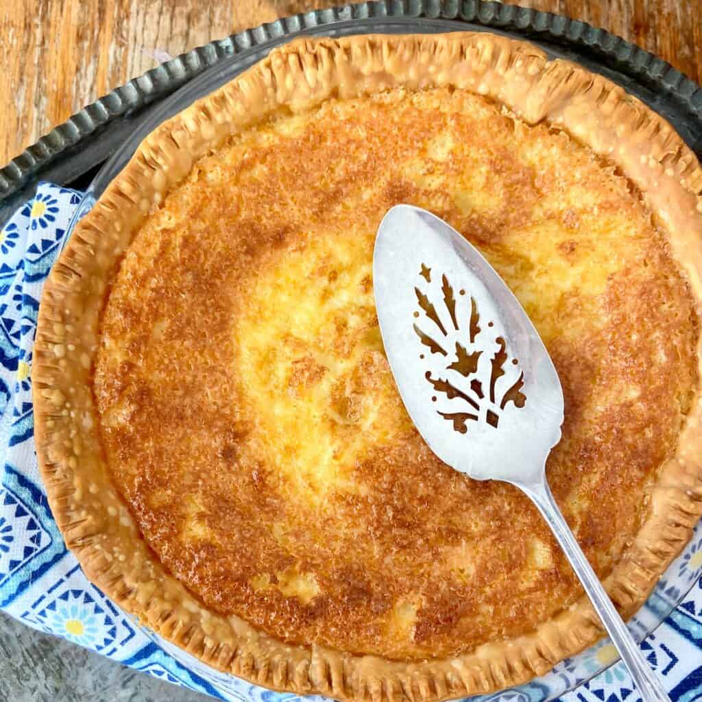 Whole buttermilk pie with sterling silver pie server.