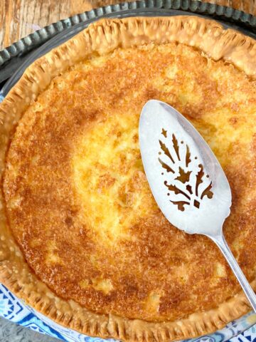 Whole buttermilk pie with sterling silver pie server.