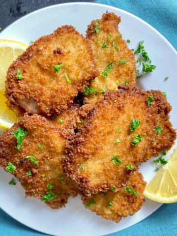 Pork schnitzel cutlets on white plate.