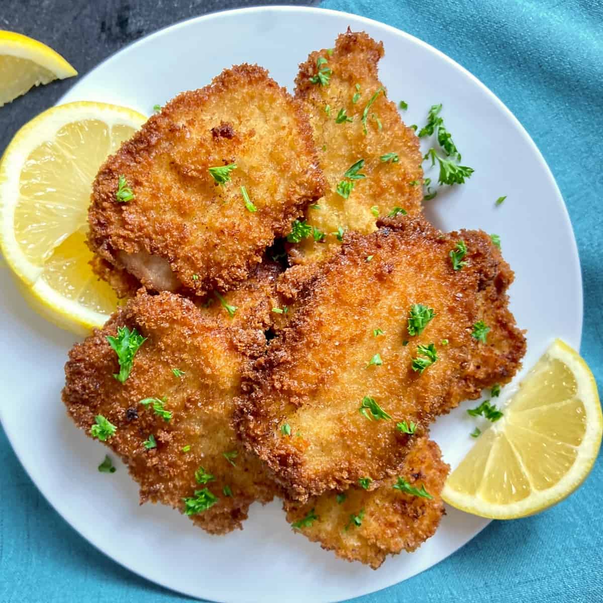 Pork schnitzel cutlets on white plate.