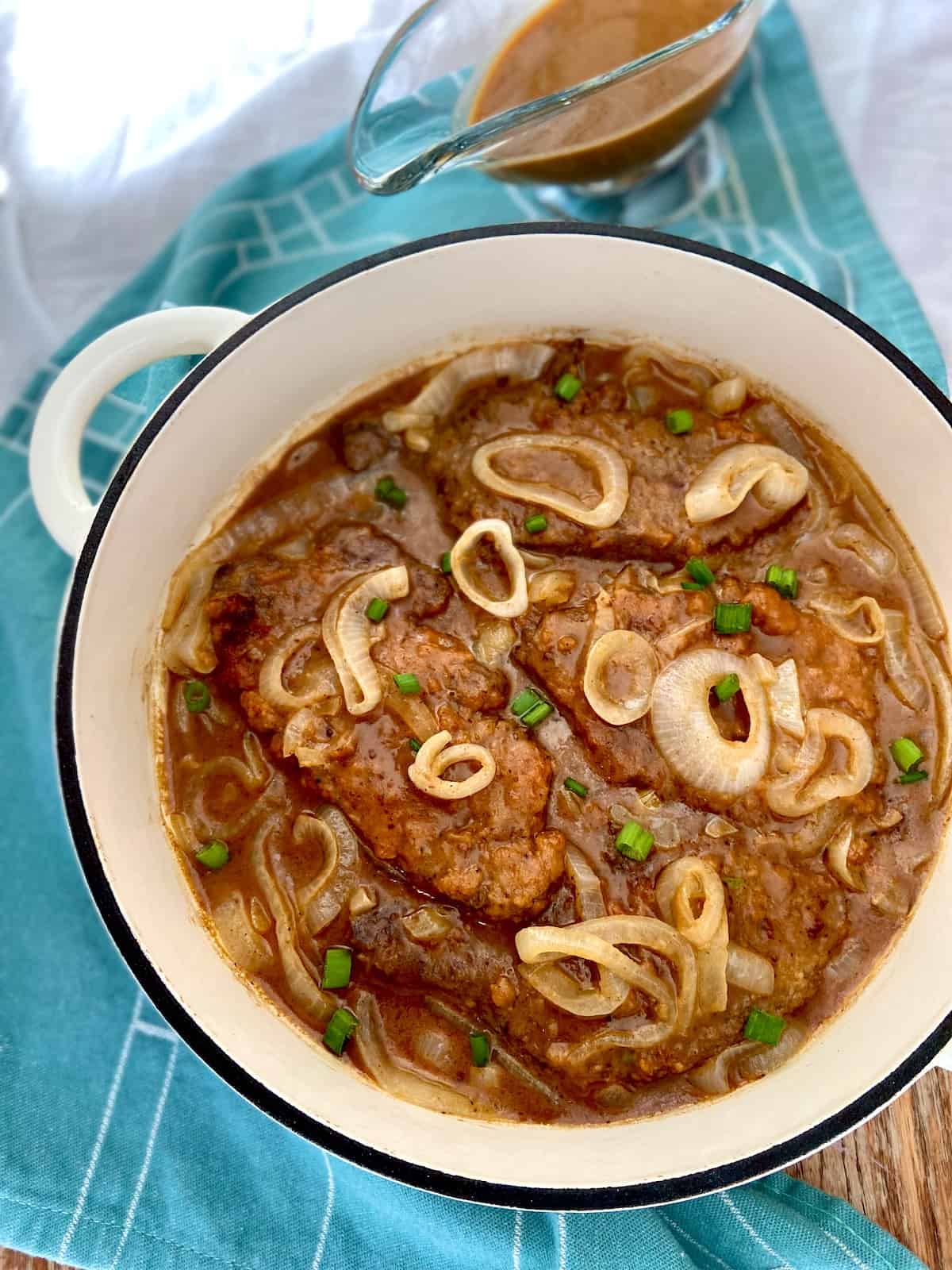 Liver and onions in a white dutch oven.