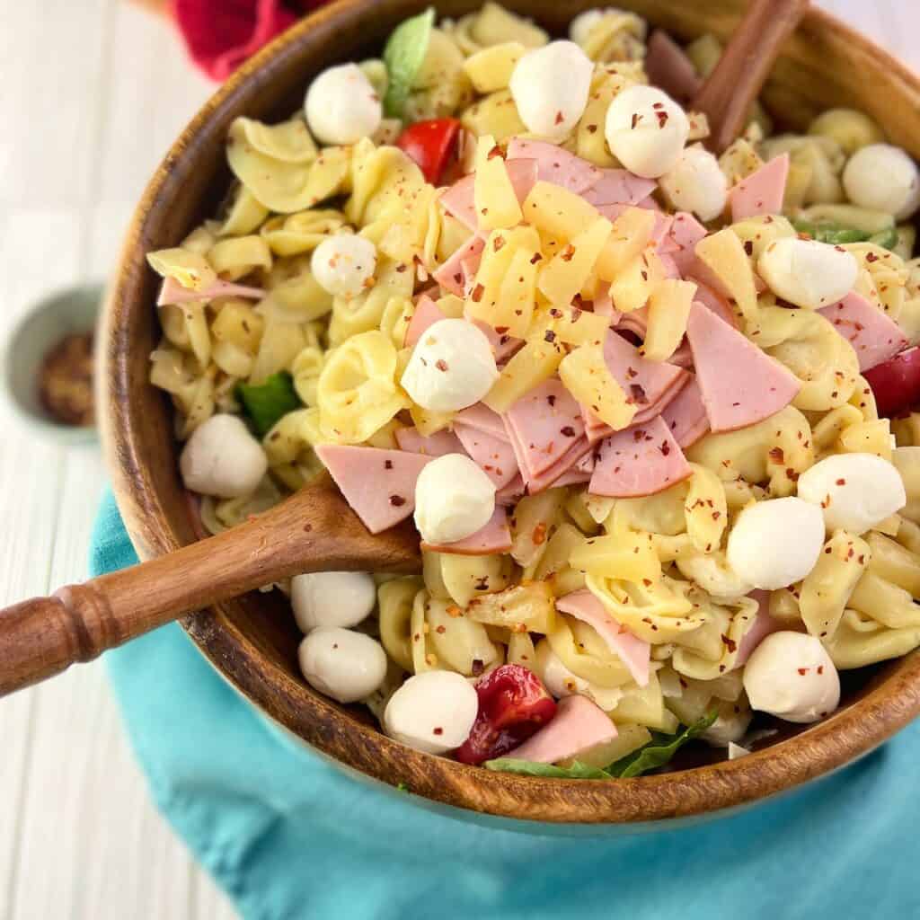 Hawaiian pasta salad with pineapple in wooden serving bowl.