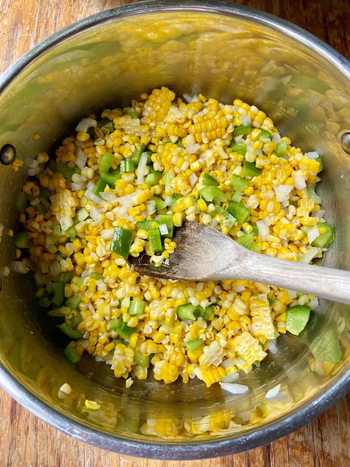 Corn and The Holy Trinity in stockpot with wooden spoon.