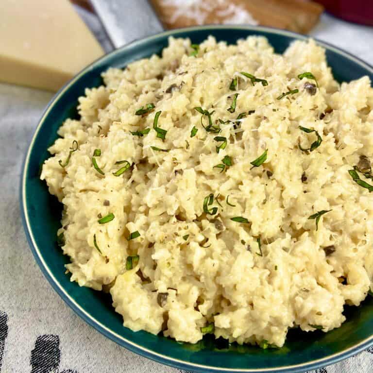 Mushroom risotto in green bowl.