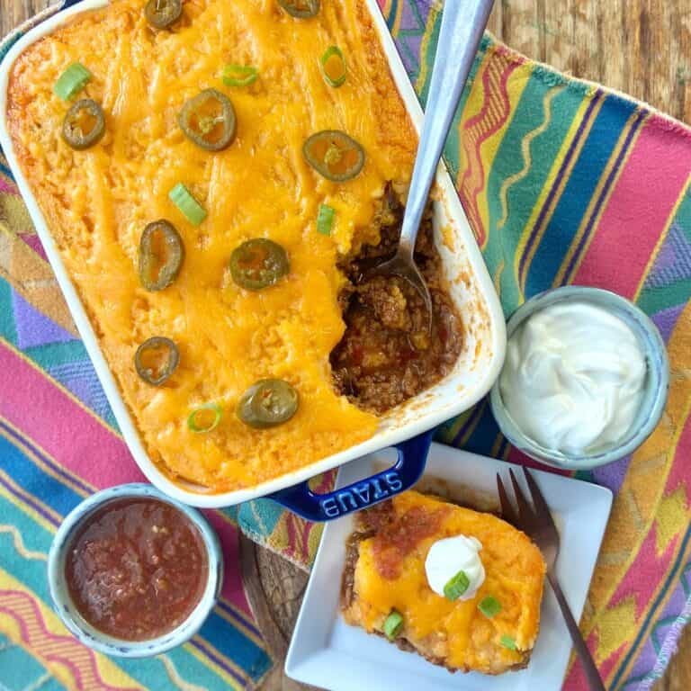 Tamale pie casserole with a side of sour cream and salsa.