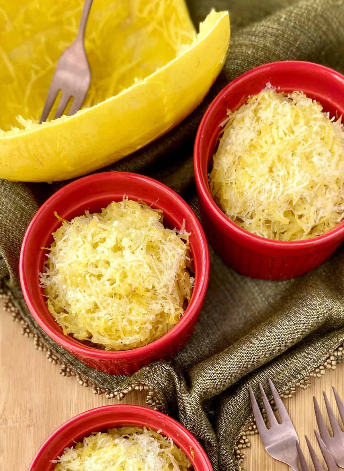 Spaghetti squash in red ramekins on wooden table.