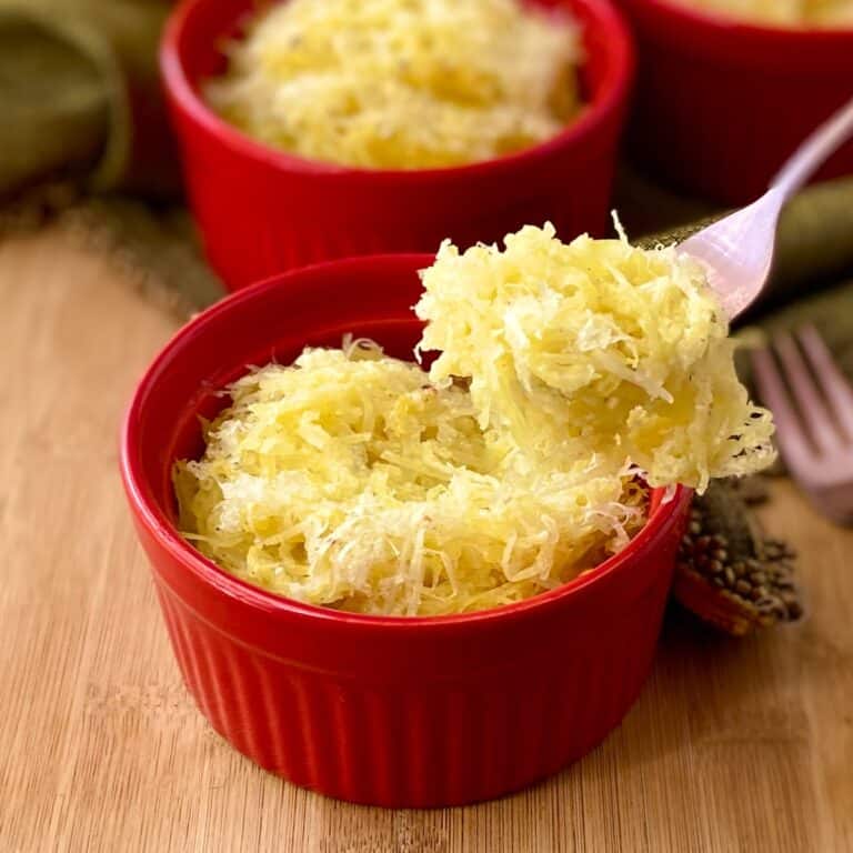 Spaghetti squash on fork over red ramekin.