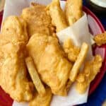 Fish and chips on red plate.