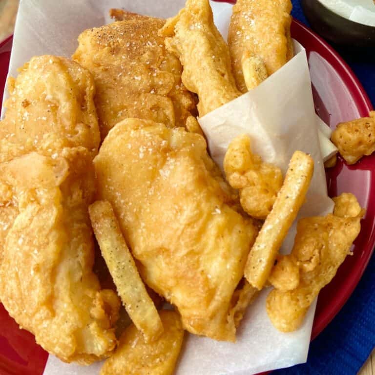 Fish and chips on red plate.