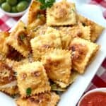 Fried raviolo on white tray.