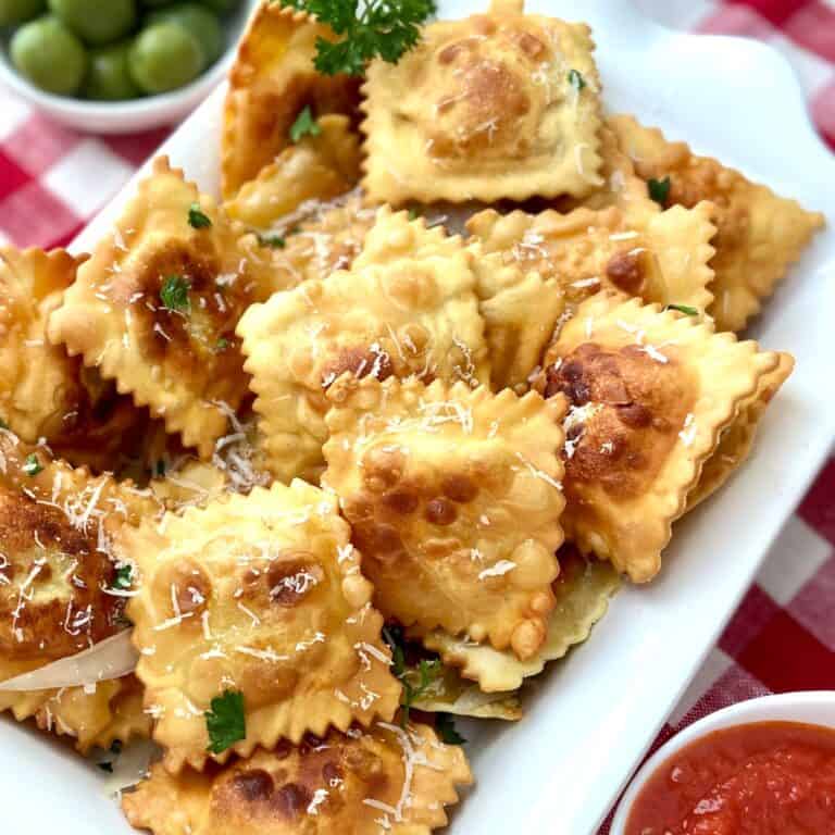 Fried raviolo on white tray.