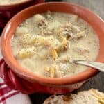 New England Clam Chowder in red bowl with spoon.