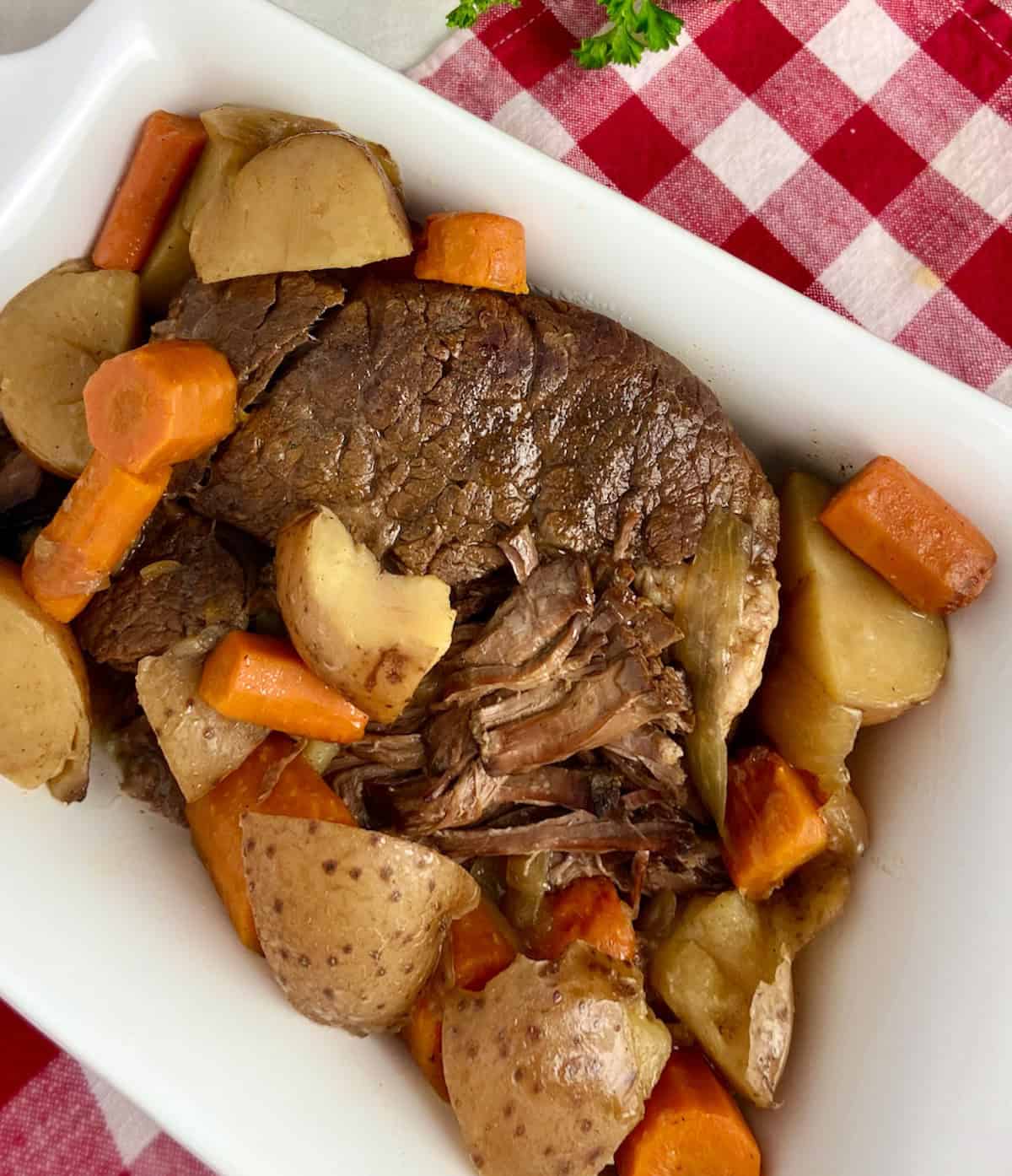 Pot roast, carrots and potatoes in serving bowl.