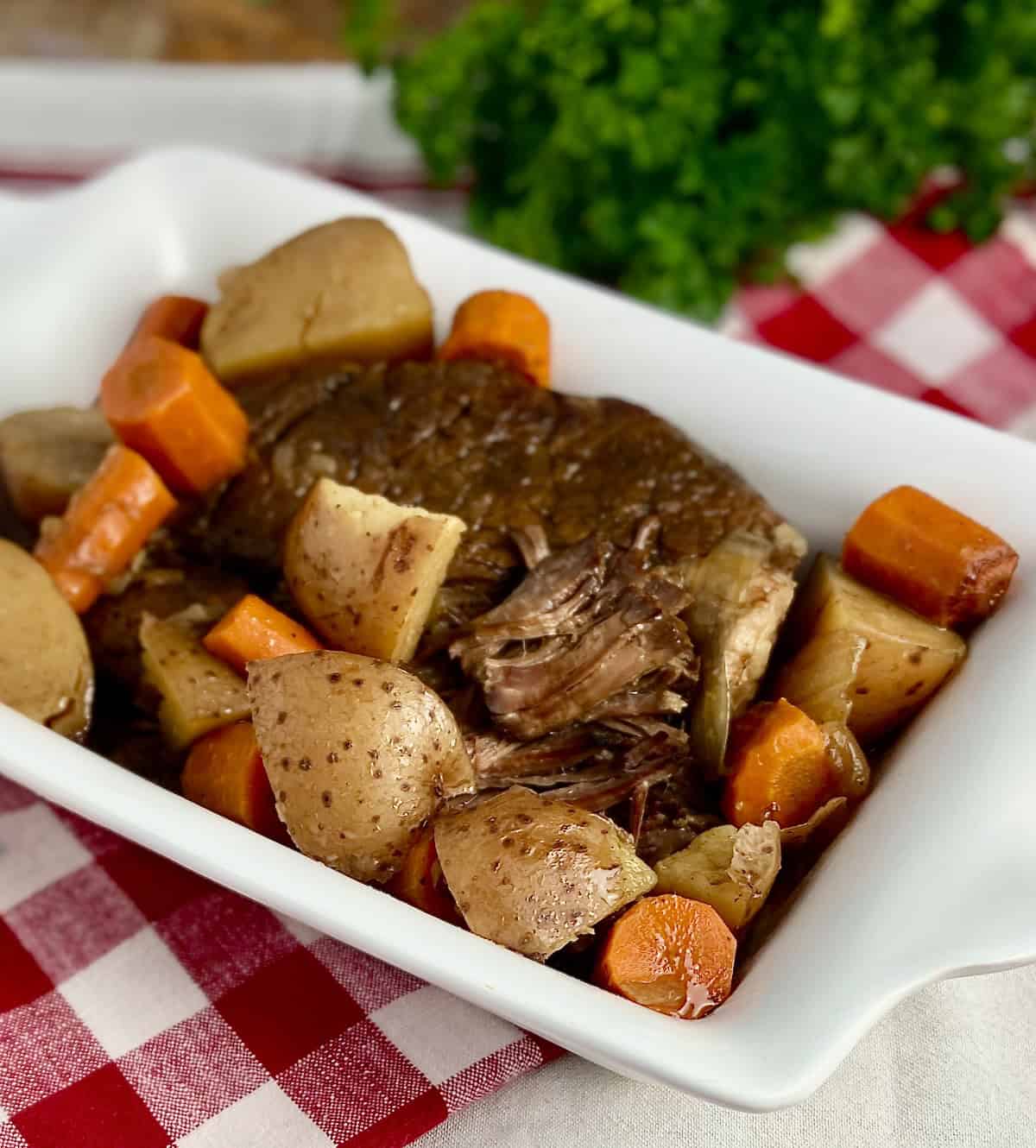Close up image of pot roast with carrots and potatoes.