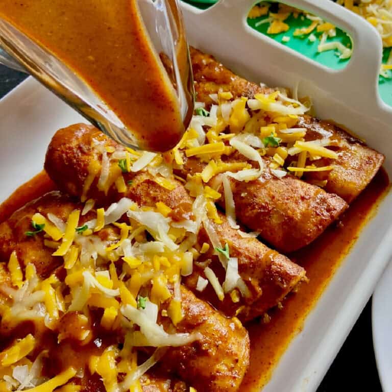 Red enchilada sauce over cheese enchiladas.