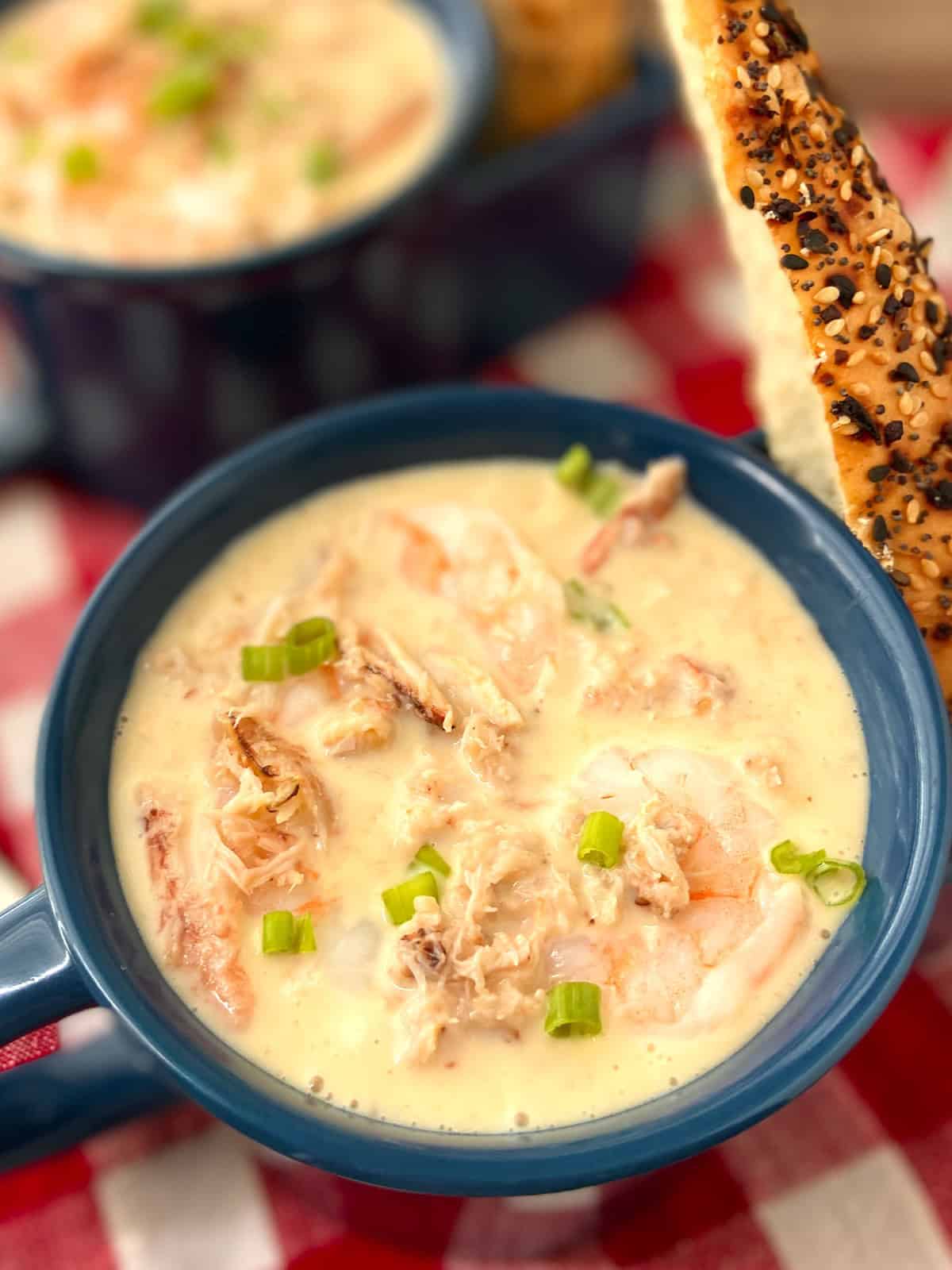 Close up image of seafood bisque garnished with chopped green onion.