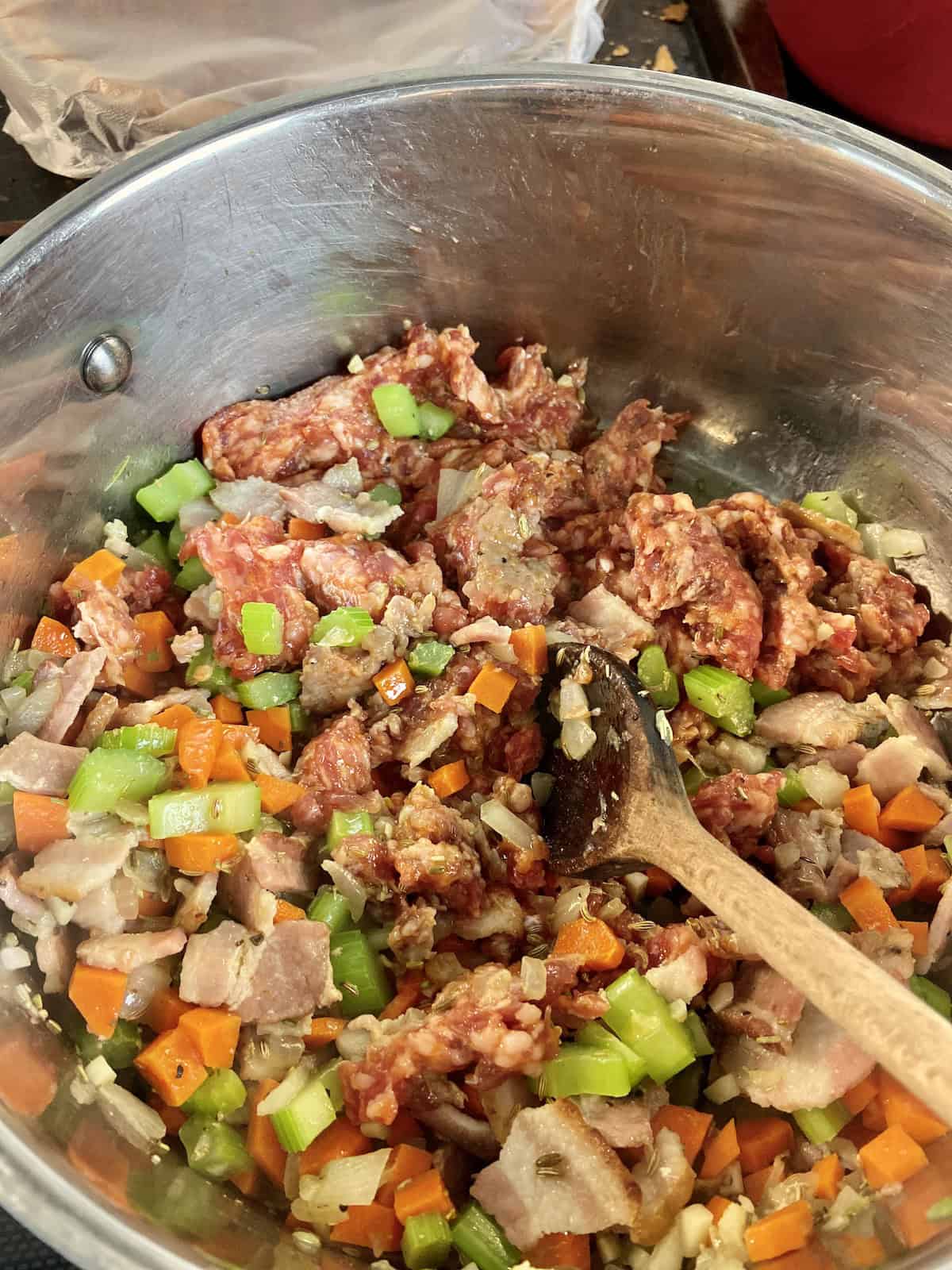 Sauteed vegetables and sausage in stockpot.