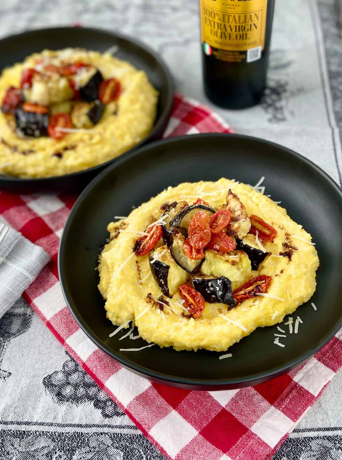 Polenta topped with eggplant, tomatoes and grated Parmesan.