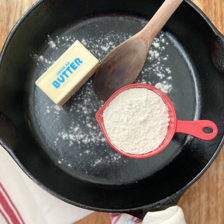 Cup of flour and a stick of butter in a cast iron skillet.