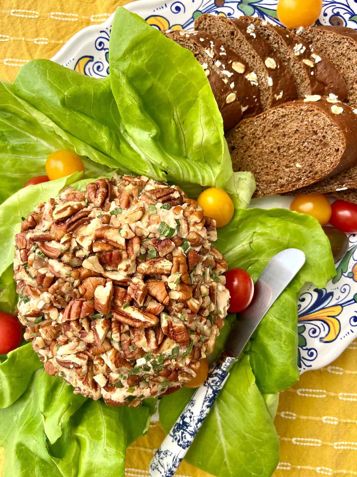 Smoked salmon cheeseball with decorative spreader on platter.