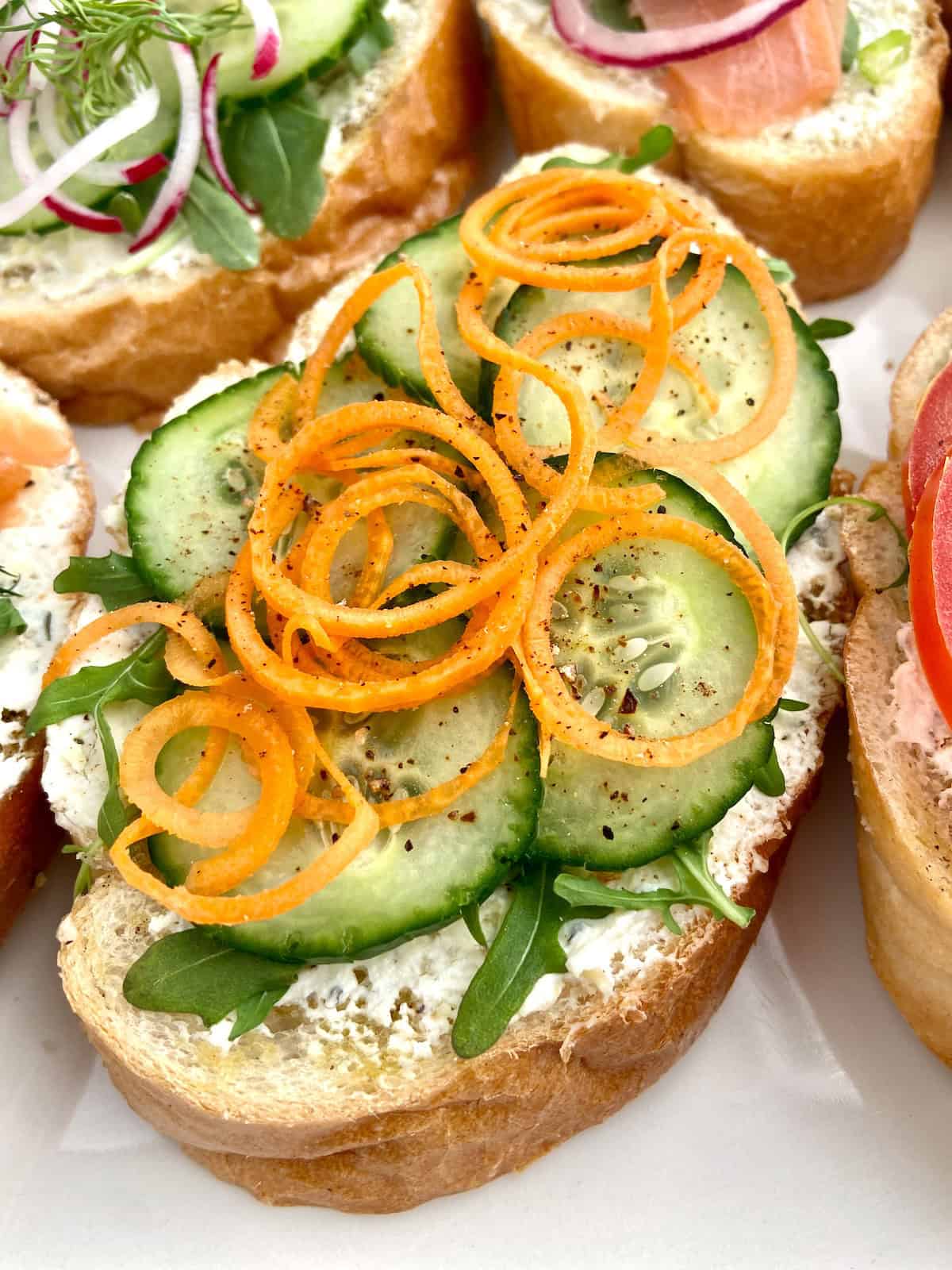 Sliced cucumbers and arugula on bread.