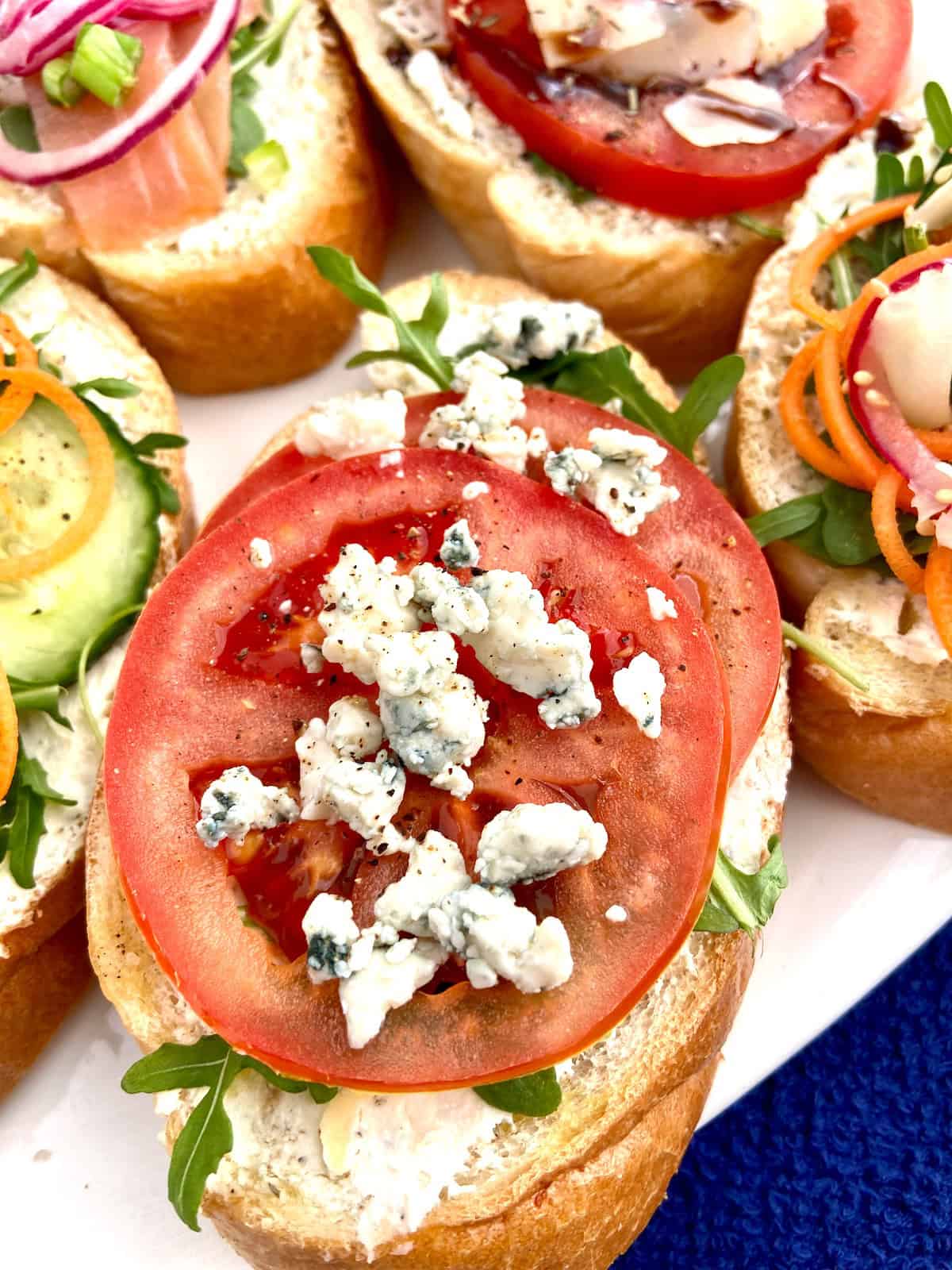 Tomato and crumbled blue cheese on bruschetta.