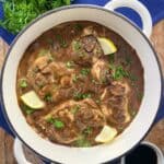 Balsamic Chicken in pan garnished with fresh parsley and lemon wedges.