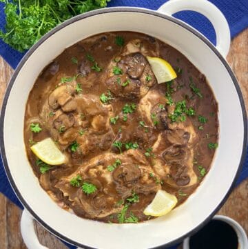 Balsamic Chicken in pan garnished with fresh parsley and lemon wedges.