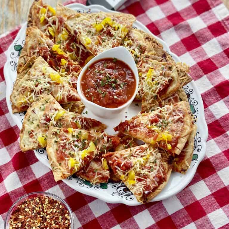 Italian nachos on serving platter with bowl of marinara.