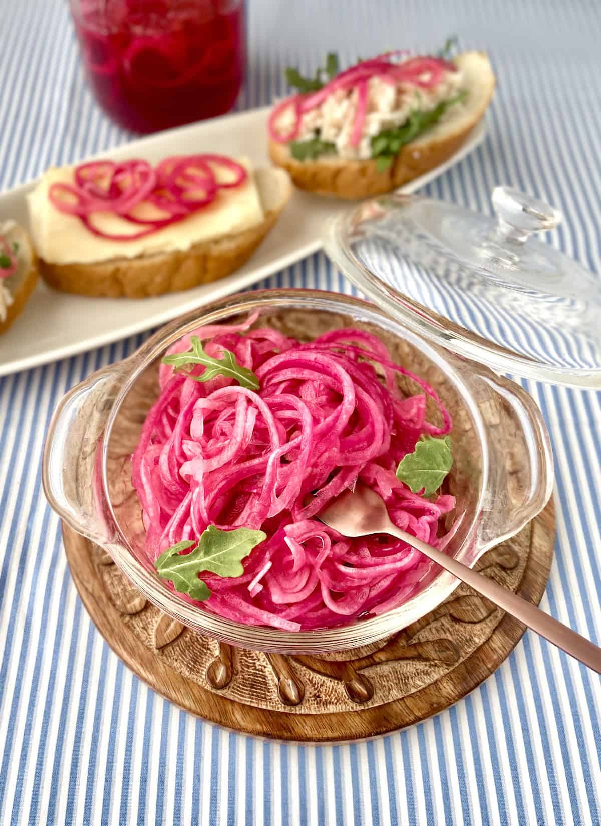 Pickled red onions in clear serving bowl.
