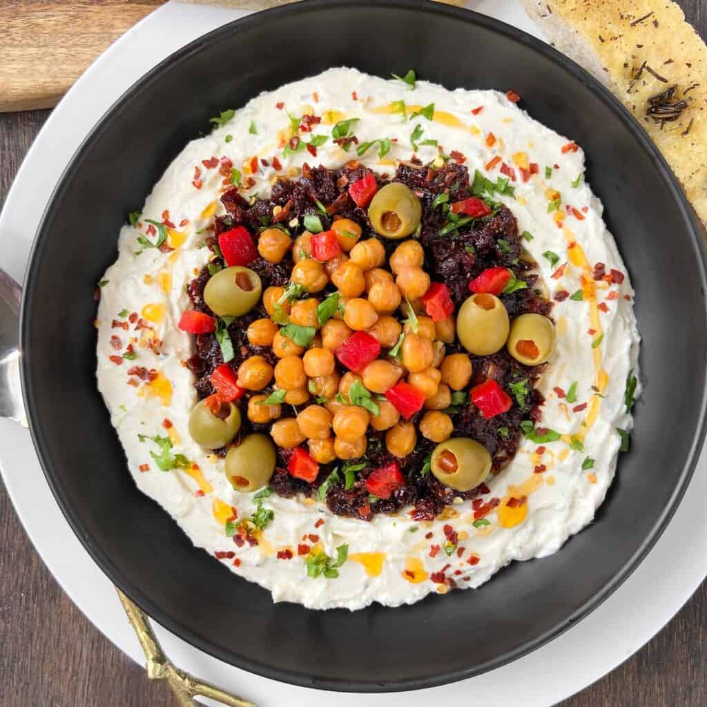 Boursin Sun Dried tomato dip in black bowl.