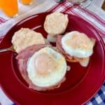 Country style eggs benedict on a biscuit with ham and cream gravy.