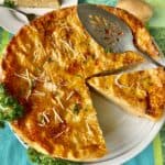 French Potato Pie in white pie plate with slotted server.