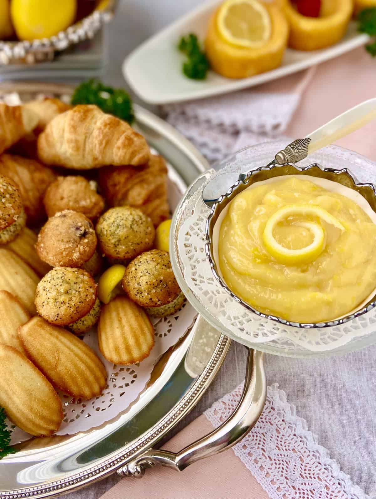 Lemon curd in a crystal bowl on a pastry tray.