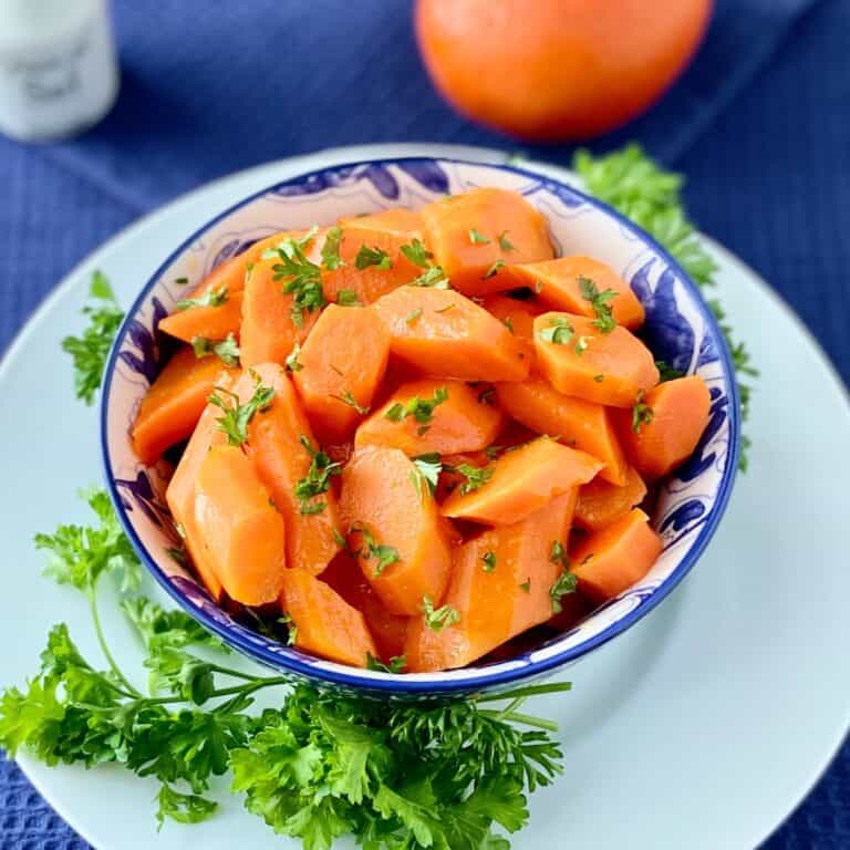 Orange Honey Glazed carrots in decorative blue bowl.