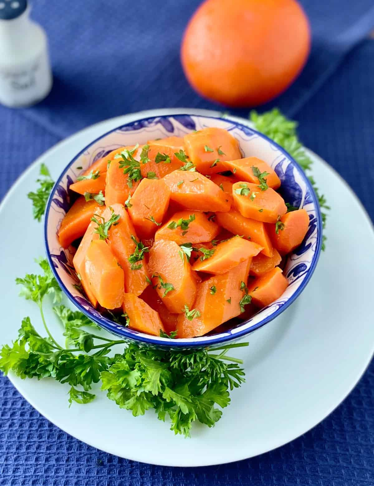 Orange Honey Glazed Carrots in decorative blue bowl.