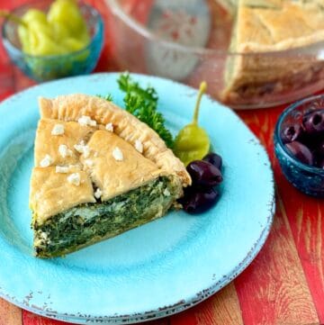 Slice of spinach pie on turquoise plate.