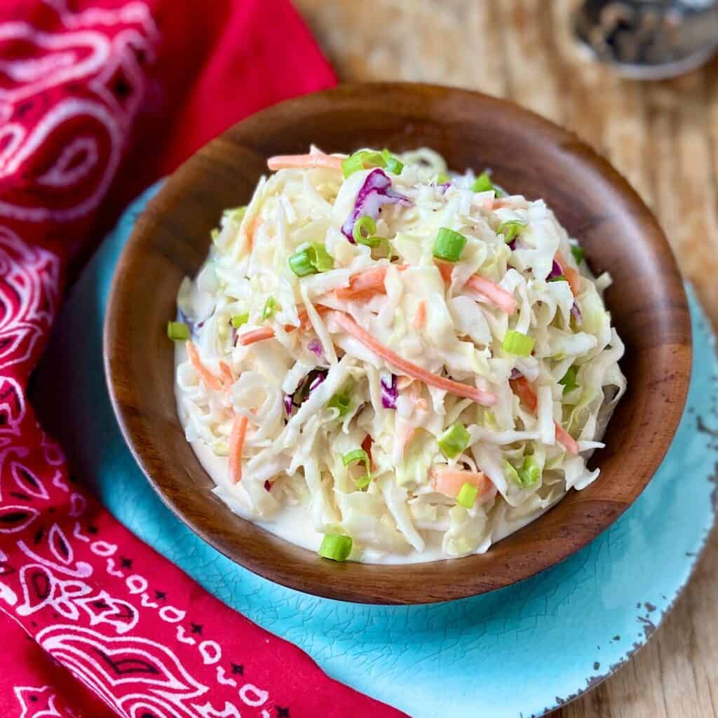 Creamy coleslaw in a wooden serving bowl.