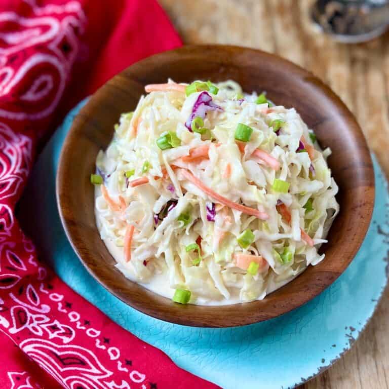 Creamy coleslaw in a wooden serving bowl.