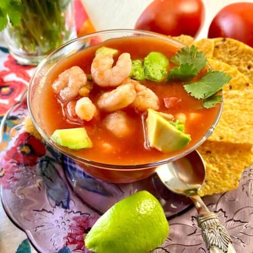 Mexican Shrimp Cocktail in glass bowl on purple charger.