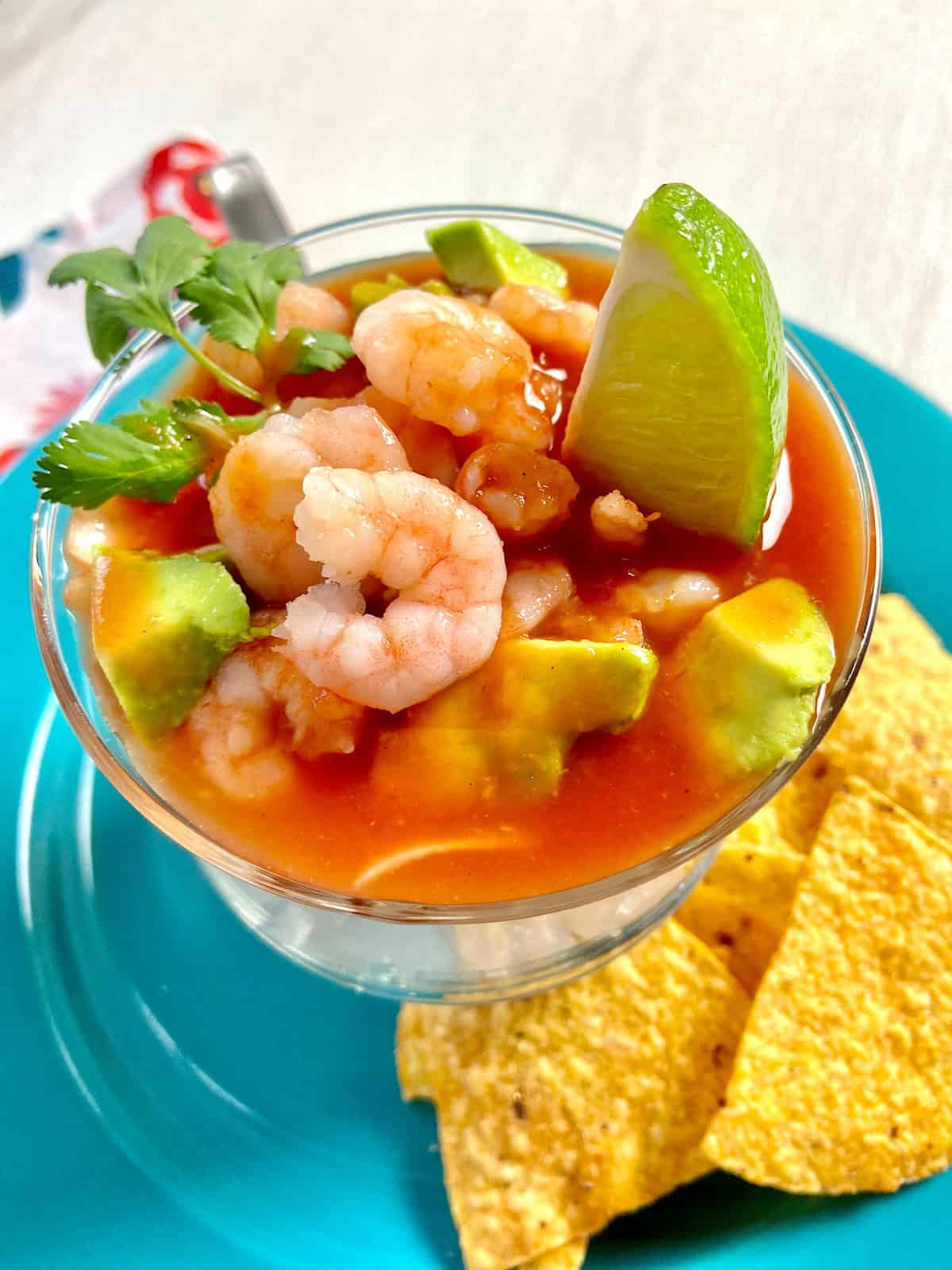 Mexican Shrimp Cocktail in glass bowl garnished with lime wedge.