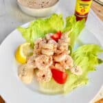 Shrimp remolaude salad on iceberg lettuce with tomato wedges.