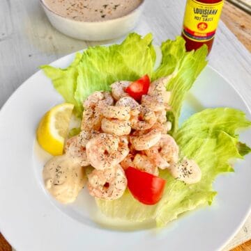 Shrimp remolaude salad on iceberg lettuce with tomato wedges.