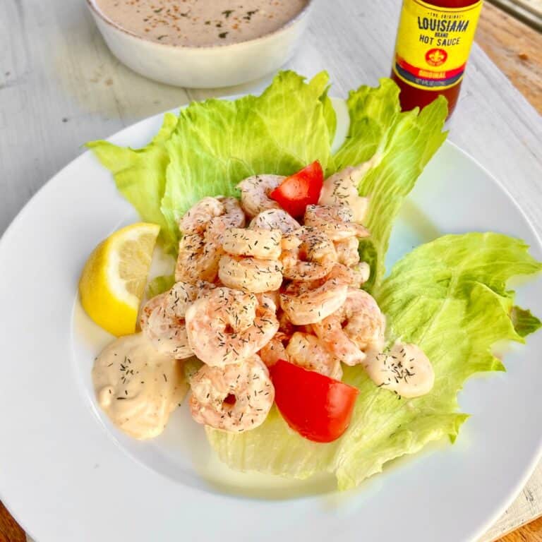 Shrimp remolaude salad on iceberg lettuce with tomato wedges.