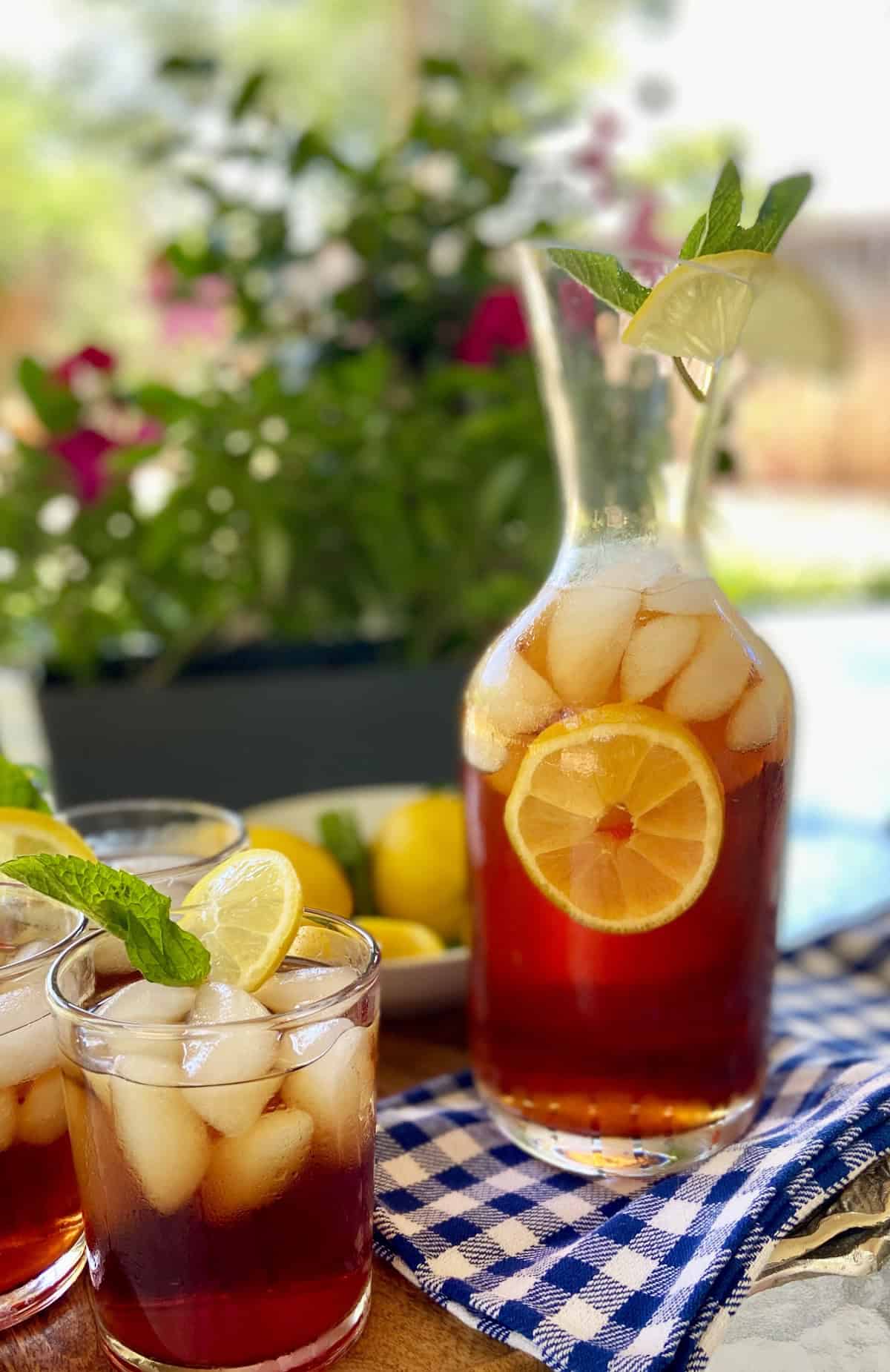 A glass of iced sweet tea on a wooden tray.