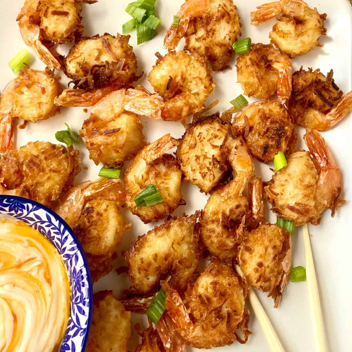 Crispy fried coconut shrimp garnished with green onion.